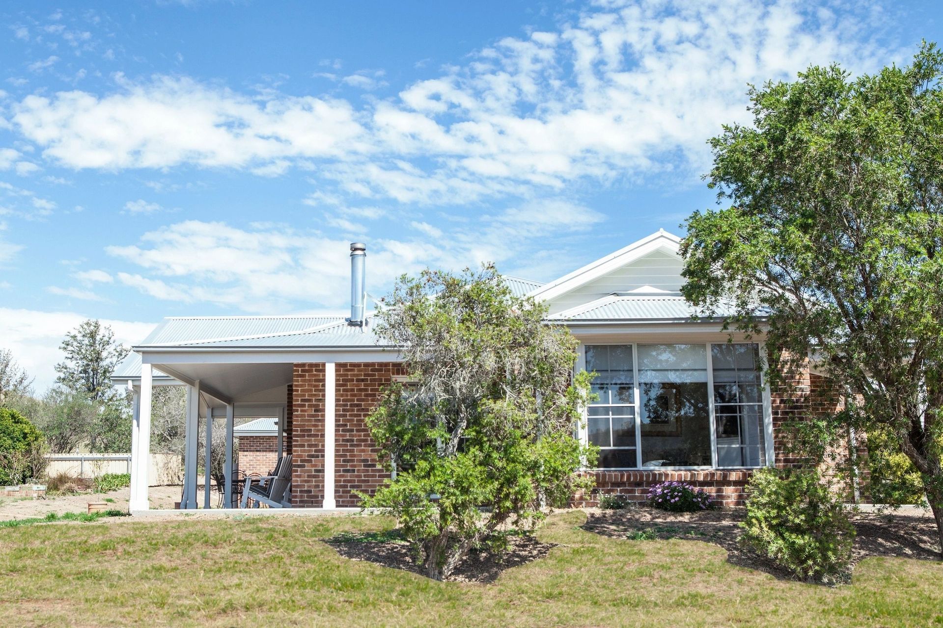 A house with a porch and trees in front of it