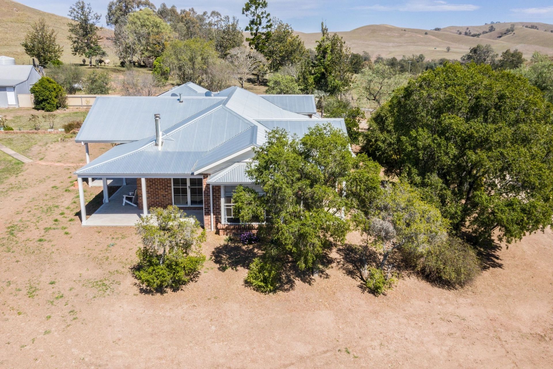 An aerial view of a house with trees in front of it