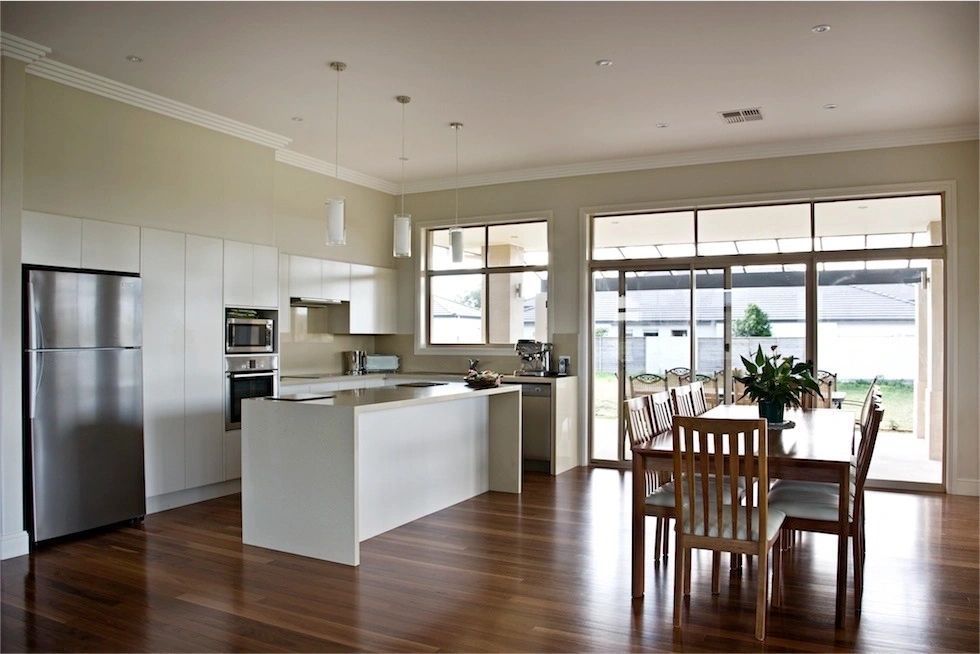 A kitchen with white cabinets and a stainless steel refrigerator