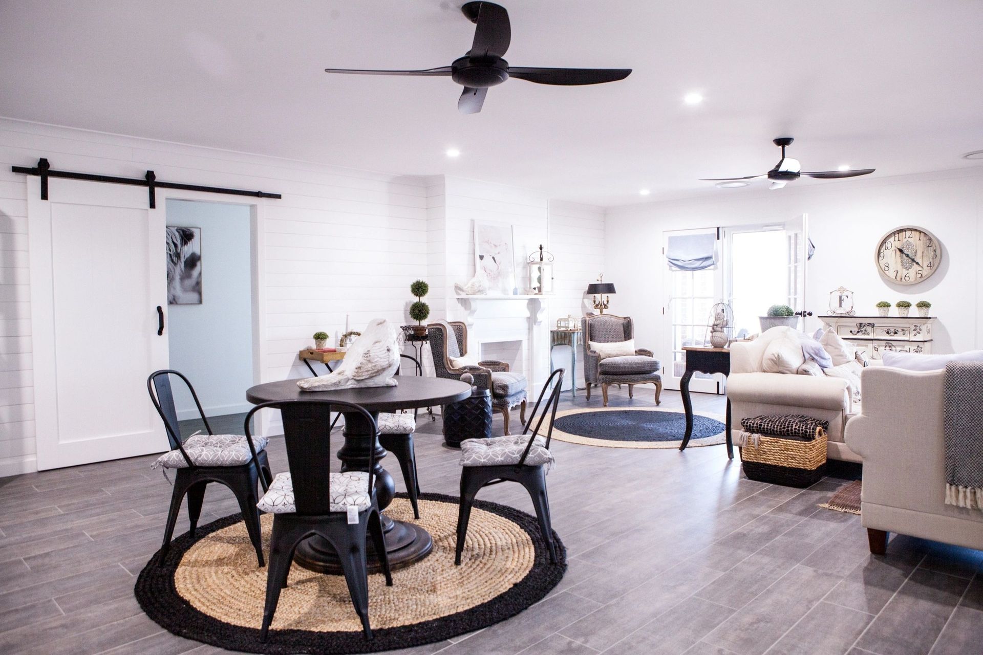 A living room with a table and chairs and a ceiling fan.