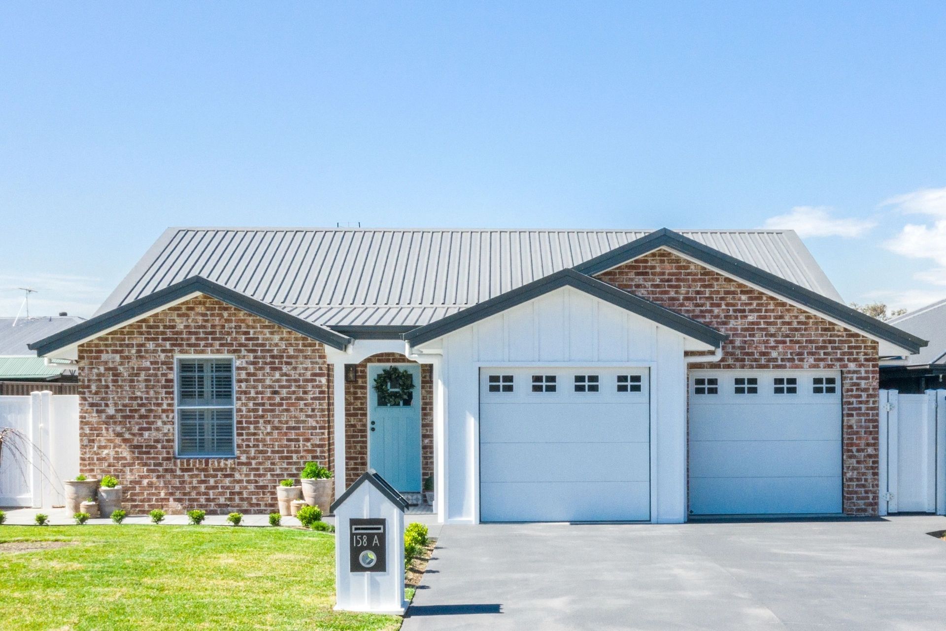 A brick house with a white garage door and a blue door.