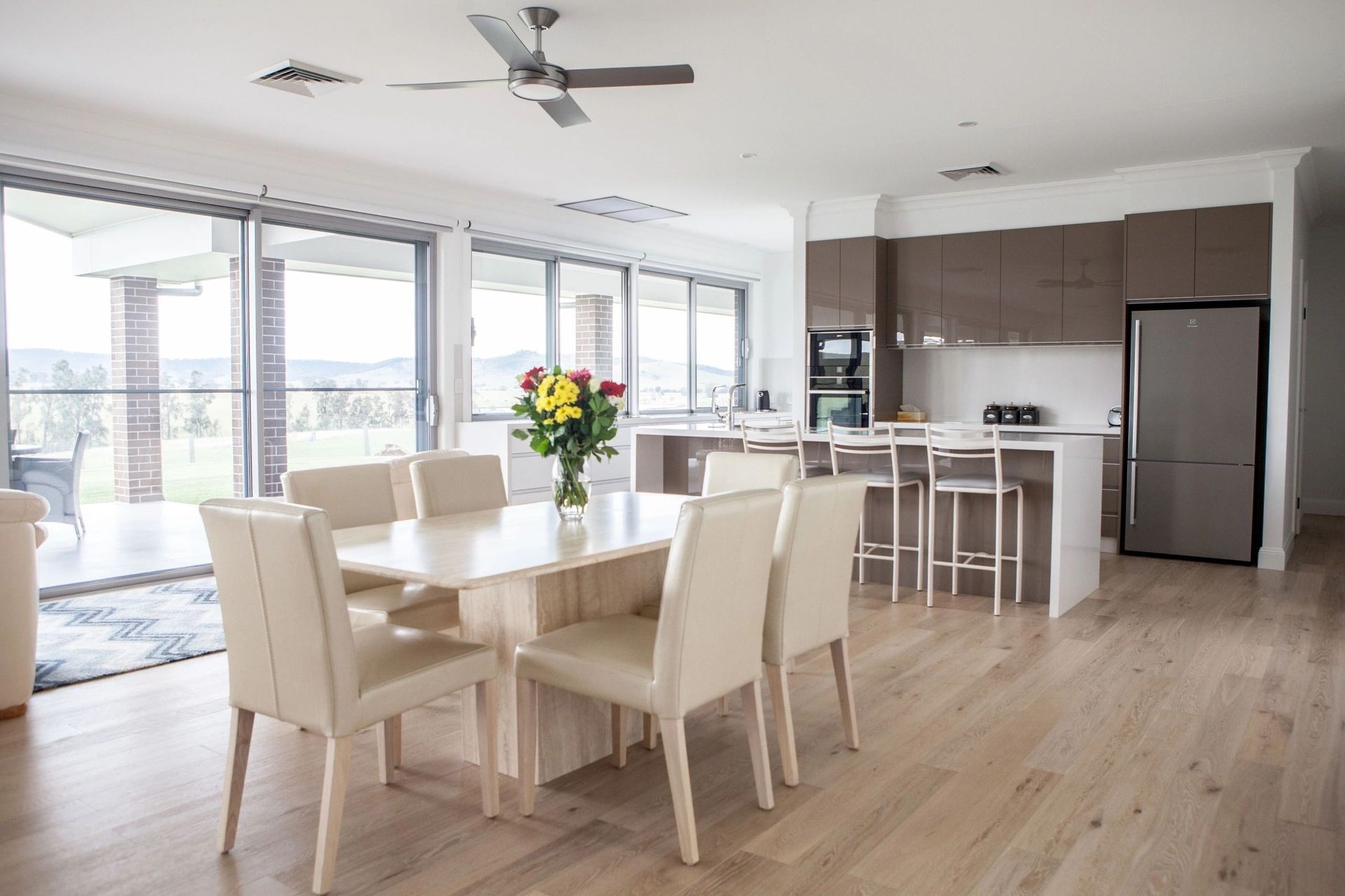 A dining room with a table and chairs and a ceiling fan