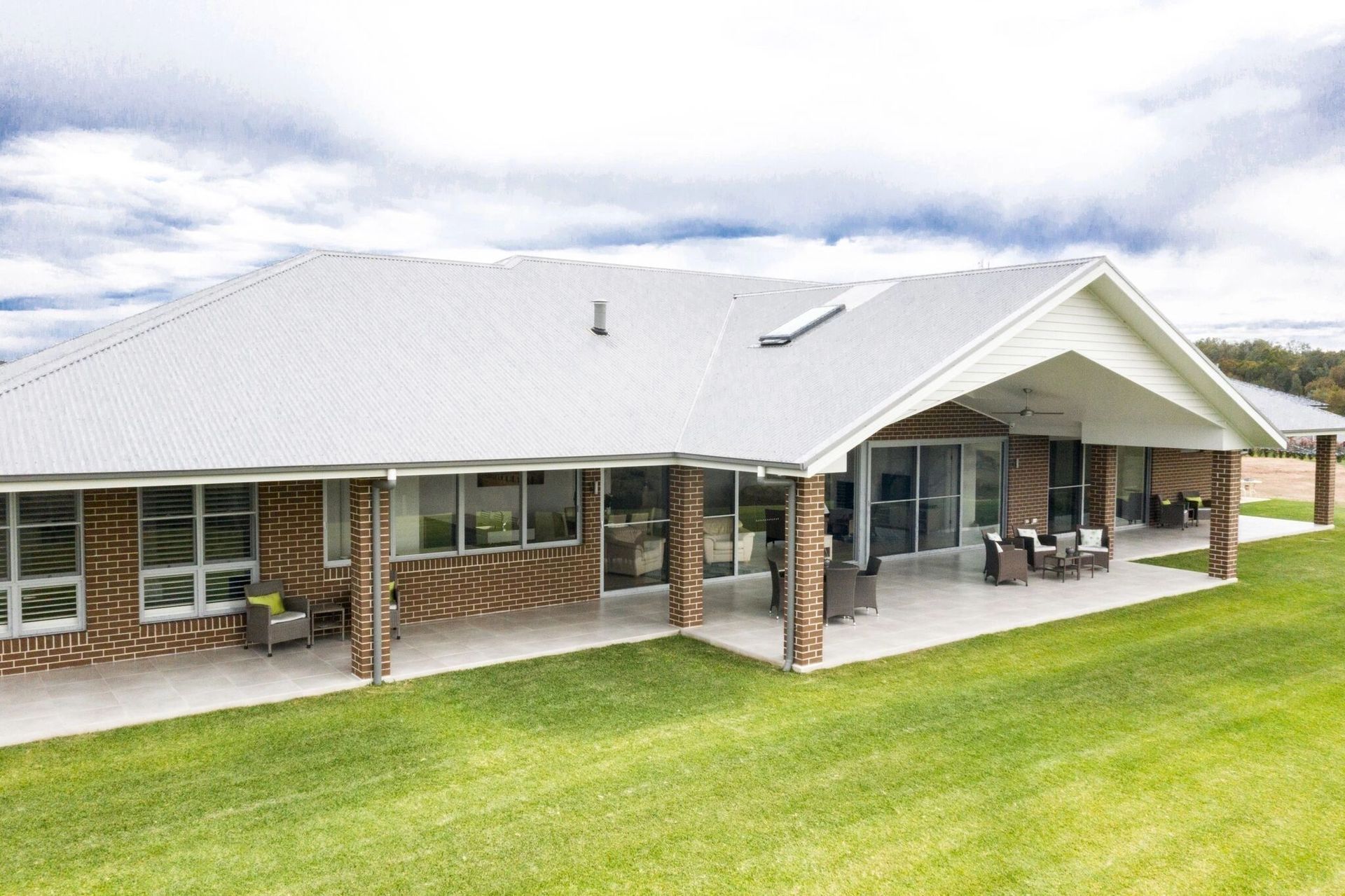 A large house with a white roof and a large lawn in front of it.