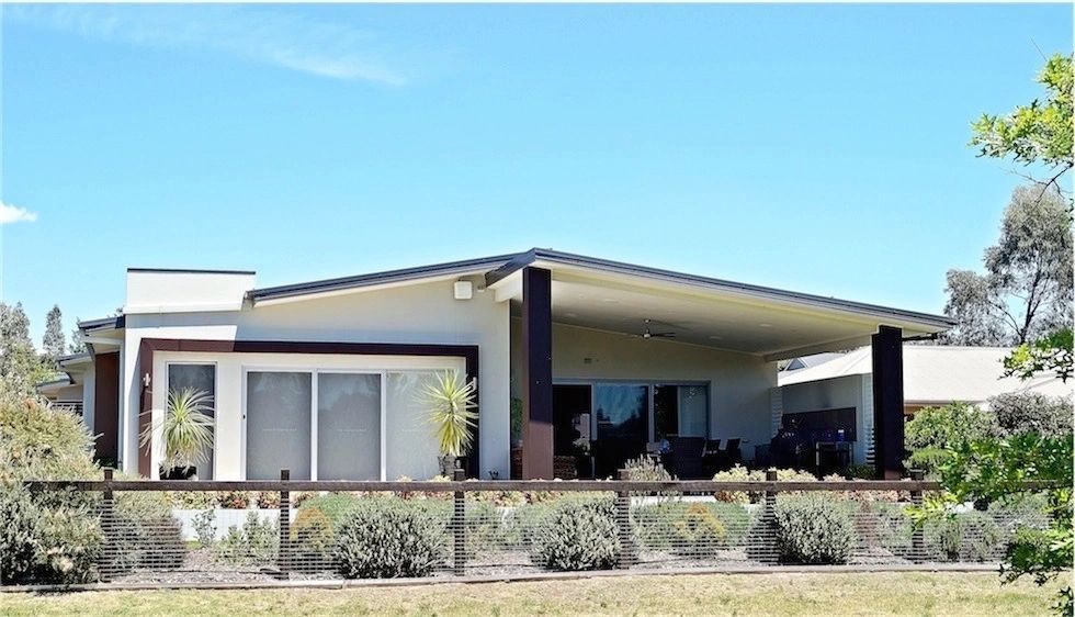 A large white house with a fence in front of it
