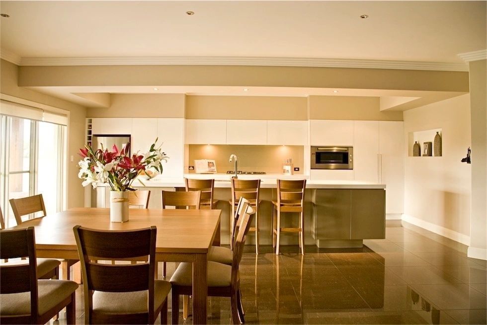 A kitchen with a table and chairs and a vase of flowers