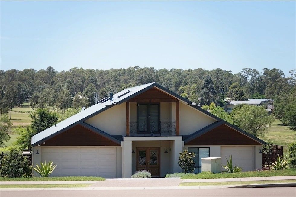 A house with a triangle shaped roof is surrounded by trees