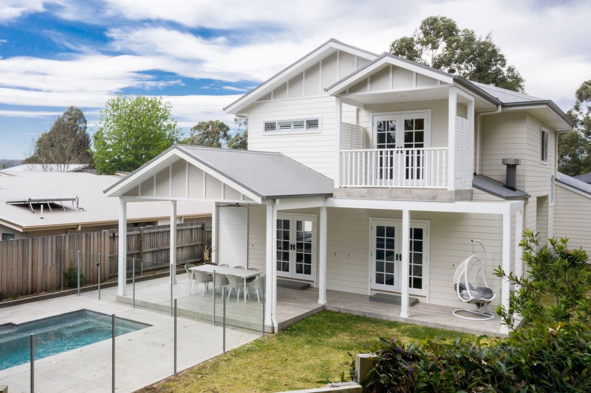 A white house with a swimming pool in the backyard.