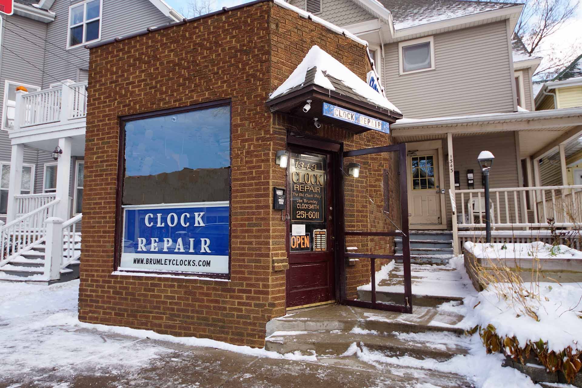 A brick building with a sign that says clock repair — Madison, WI — Brumley's Old Clock Shop A brick building with a sign that says clock repair — Madison, WI — Brumley's Old Clock Shop