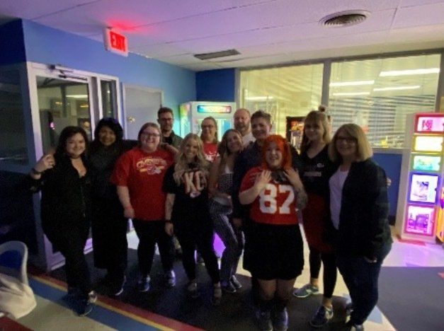 A group of people are posing for a picture in a hallway.