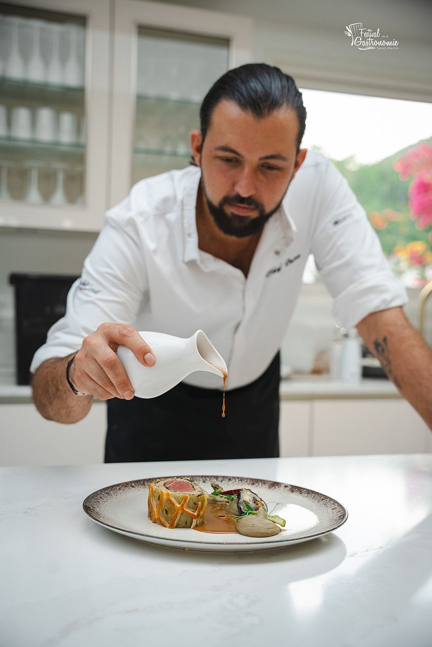 A man in an apron is preparing food in a kitchen.