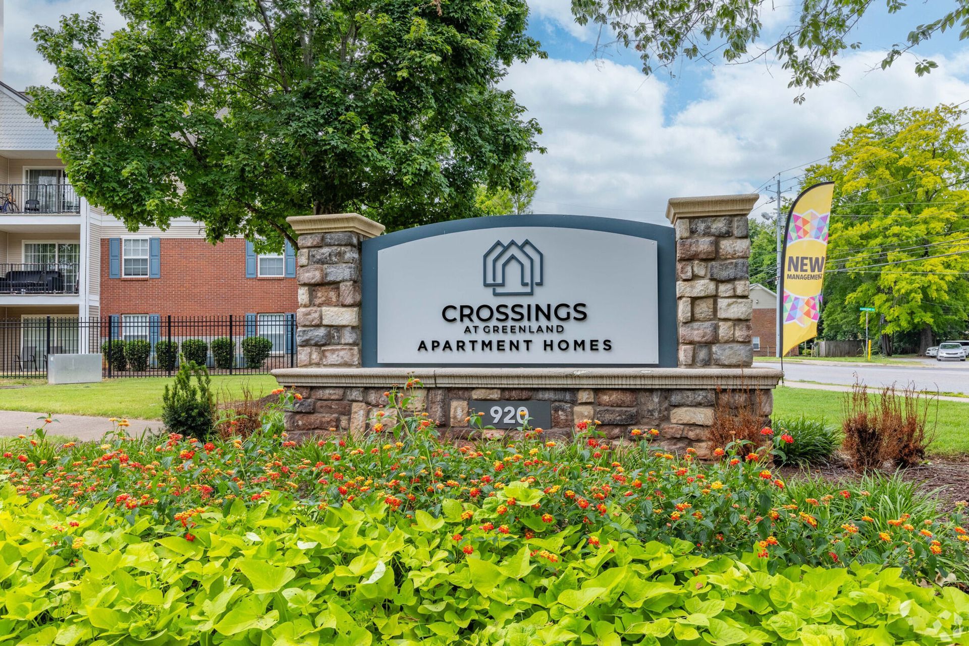 Sign for Crossings at Overbrook apartment homes. Brick and stone structure with landscaping.