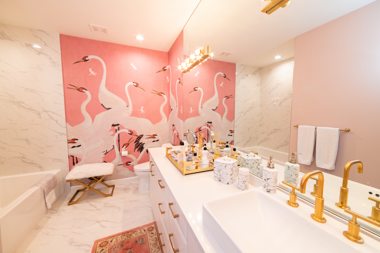 A bathroom with a pink wall and swans on it.