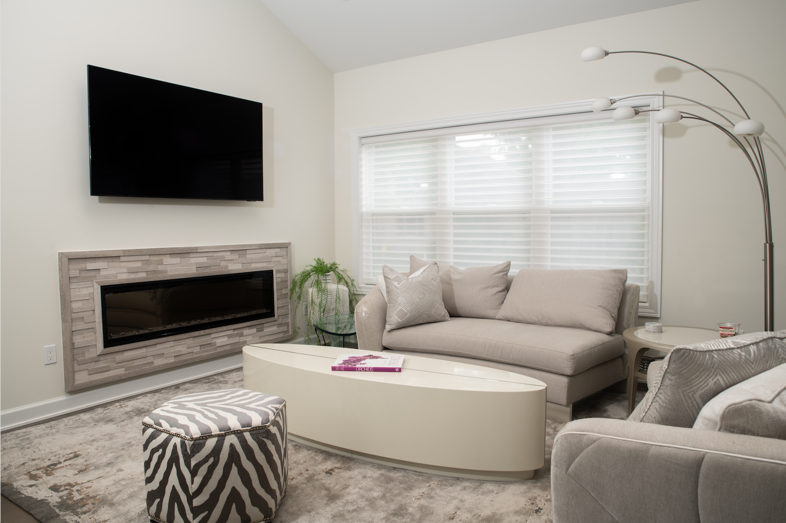 A living room with a couch , coffee table , fireplace and television.