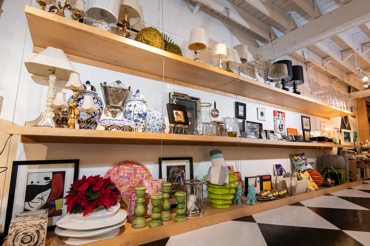 A store filled with lots of plates , vases , lamps , and other items.