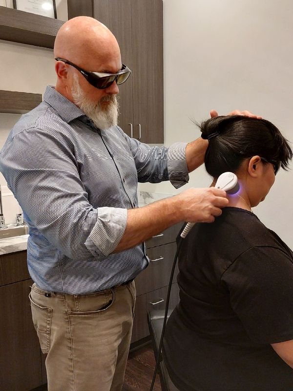 A man is giving a woman a massage on her neck.