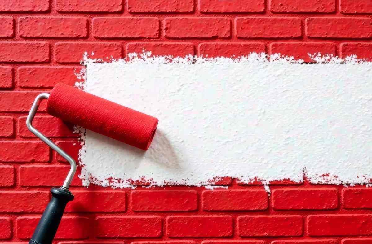  A paint roller on a brick background with red and white paint at 21st Century Paints near Holland, Ohio (OH)