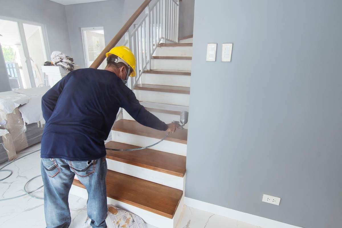 Image of a person using a paint sprayer inside a home