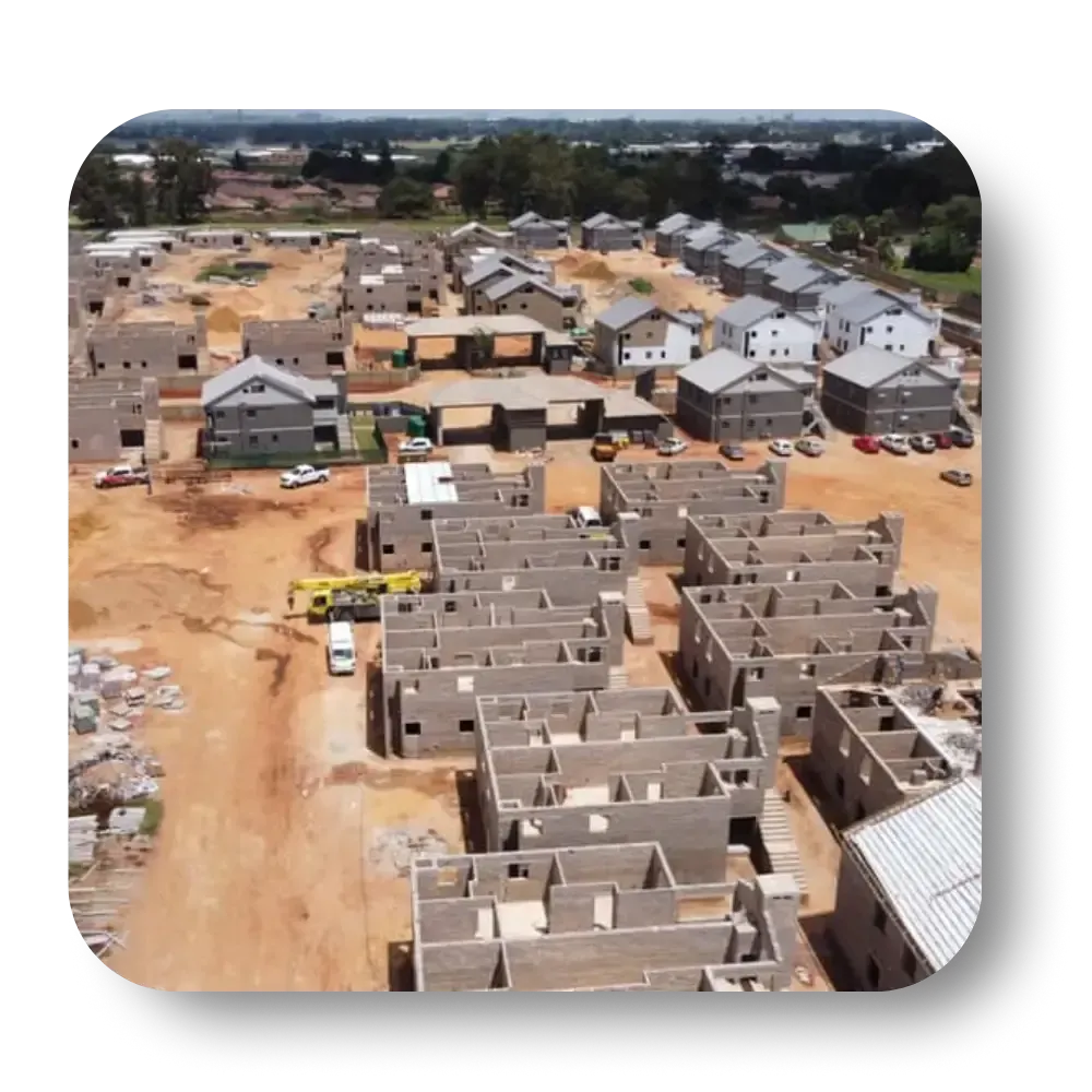 Aerial view of a construction site with numerous unfinished buildings and construction vehicles.