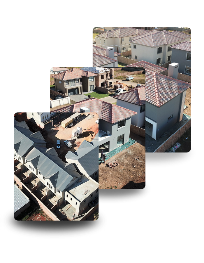 Aerial view of homes under construction, showing rooftops and surrounding land.