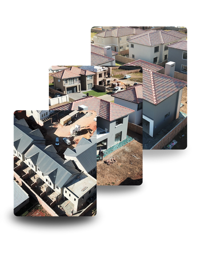 Aerial view of homes under construction, showing rooftops and surrounding land.