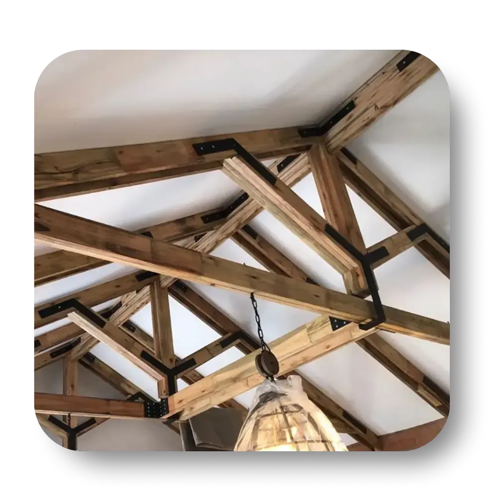 Wooden rafters with metal brackets forming a ceiling, lit by a hanging lamp.