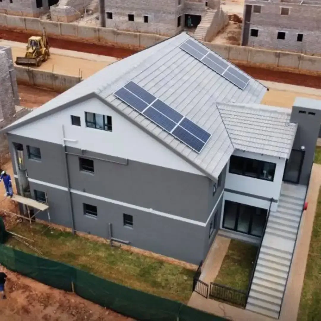 A partially constructed brick house with a white roof in a rural area.