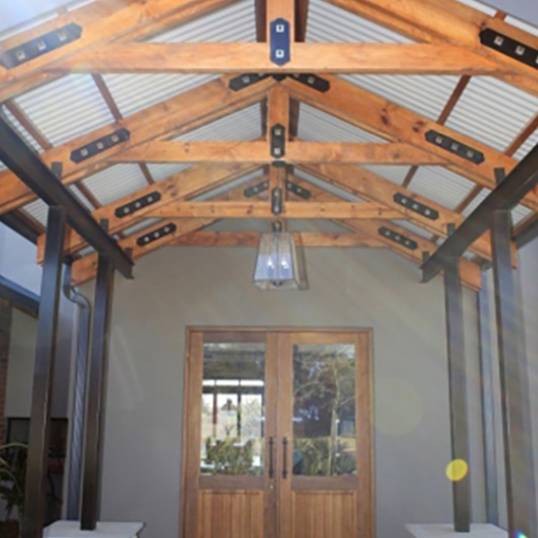 Wooden porch roof over double doors with a hanging light.