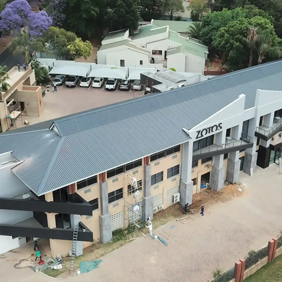 Exterior view of ZOROS building with a gray roof and parked cars.