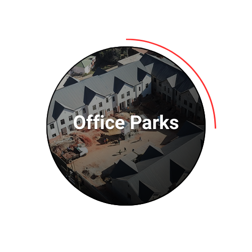 Aerial view of office park under construction; white buildings, brown dirt, 