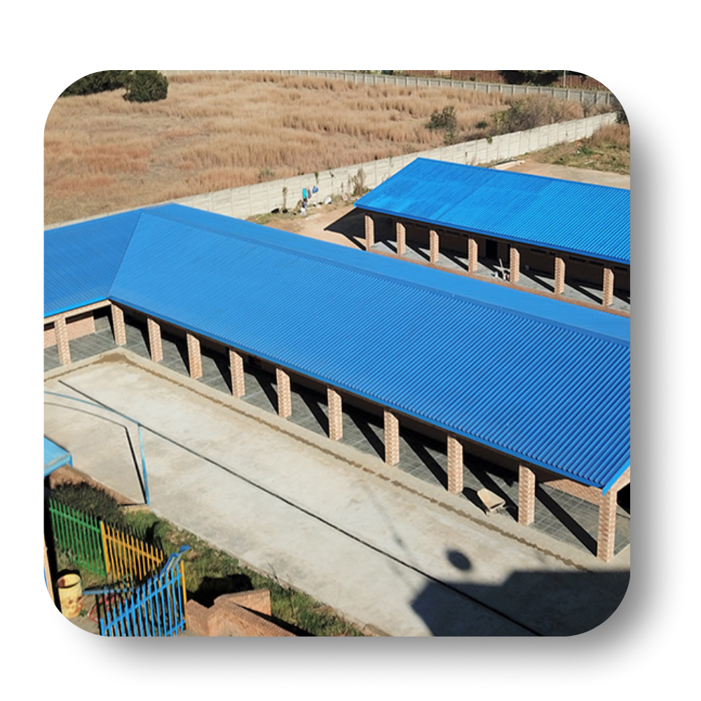 Two long buildings with blue roofs and brick pillars in an outdoor setting.