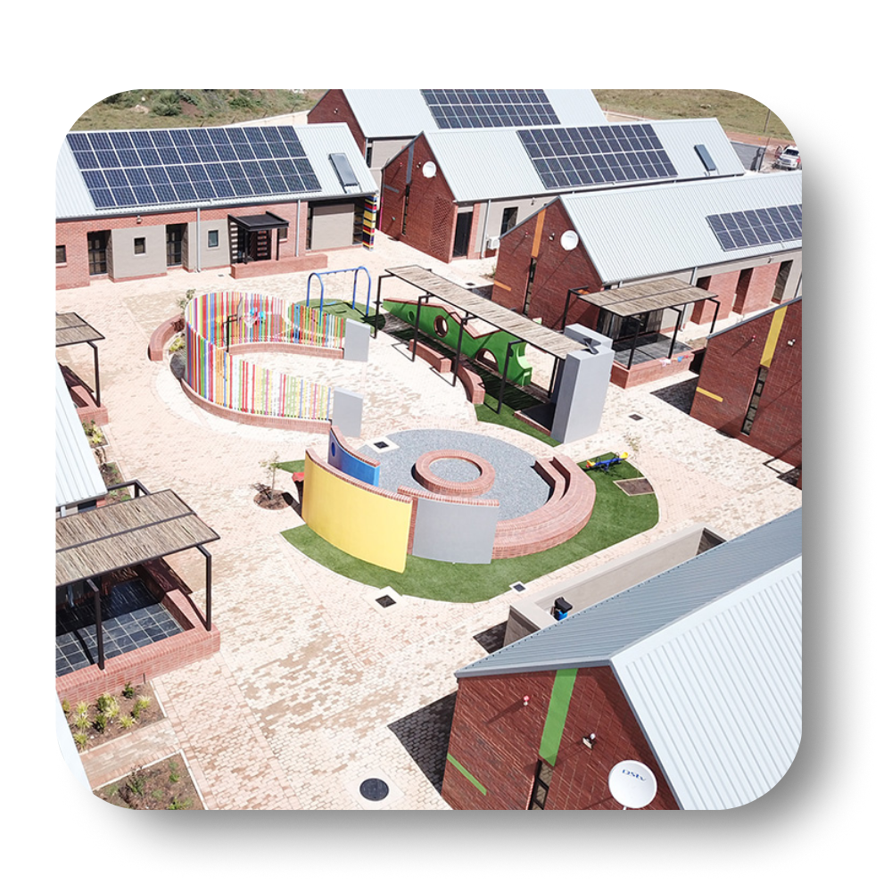 Courtyard with solar panels on rooftops, surrounded by colorful structures and brick buildings.