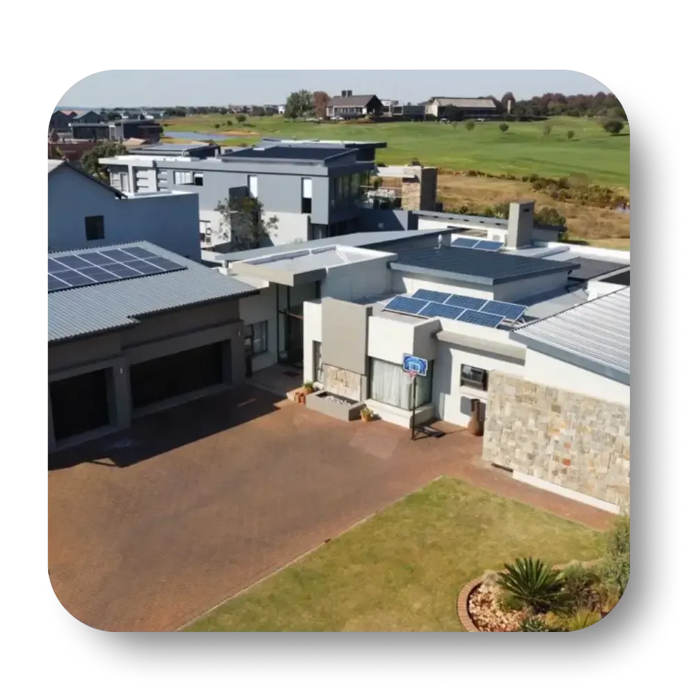 Modern homes with solar panels on rooftops, with a golf course in the background.