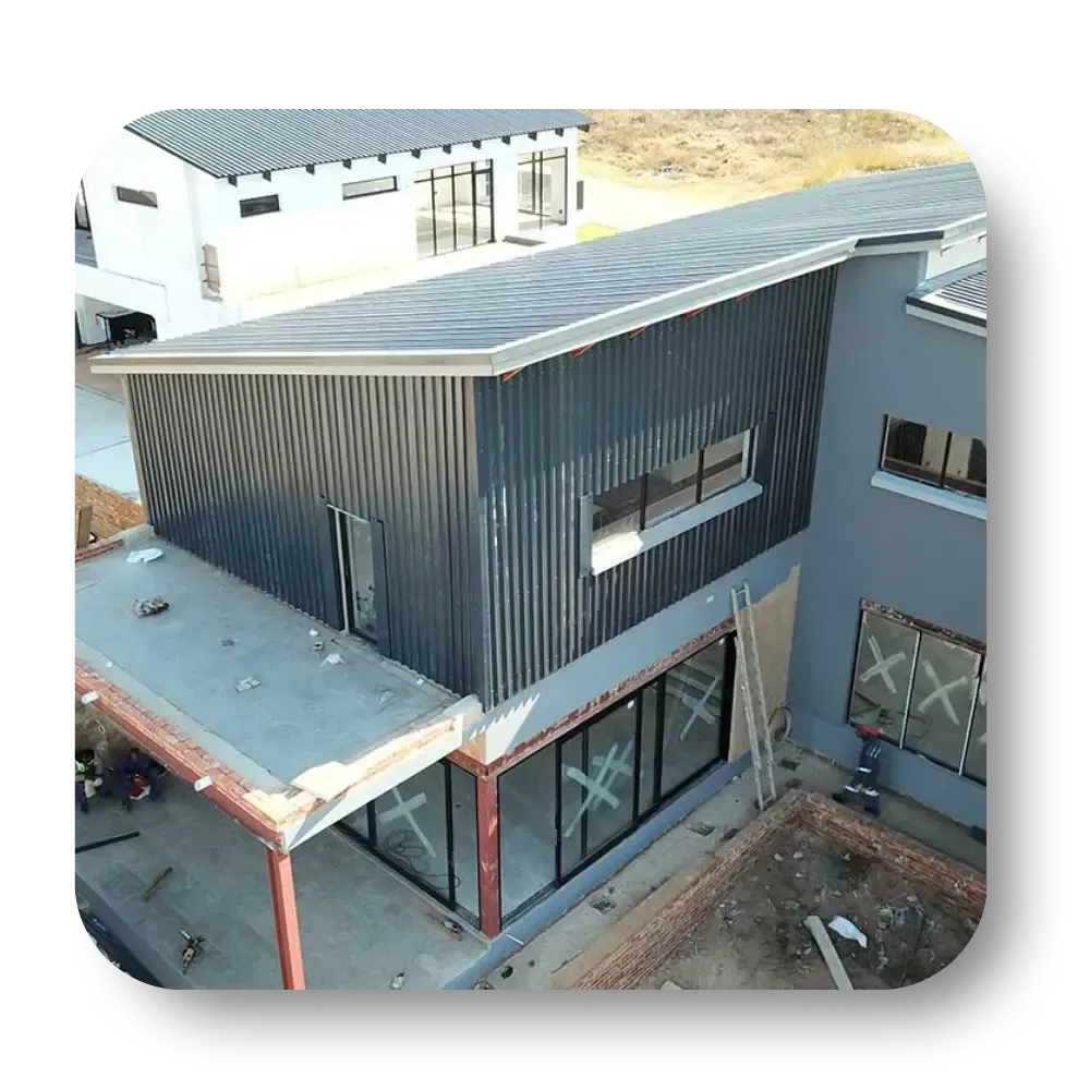 Modern house exterior with corrugated metal siding, flat roof, large windows.