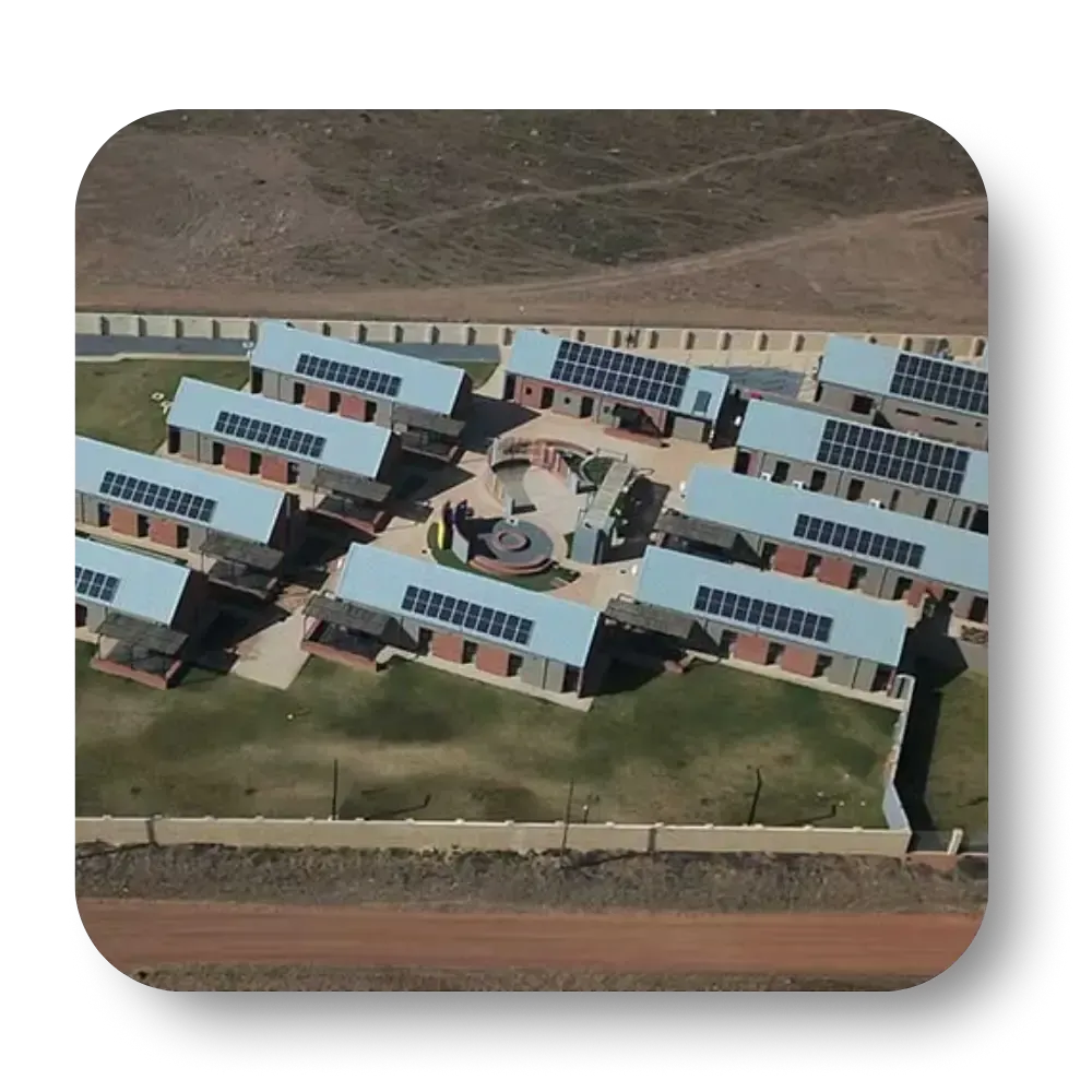 Aerial view of buildings with solar panels on roofs, clustered around a central courtyard.