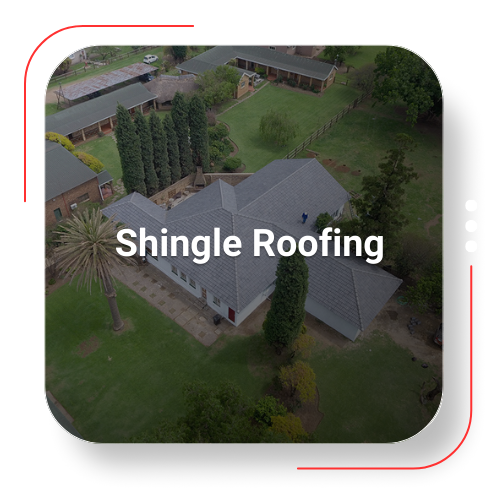 Aerial view of a house with gray shingle roofing, surrounded by trees and lawn.