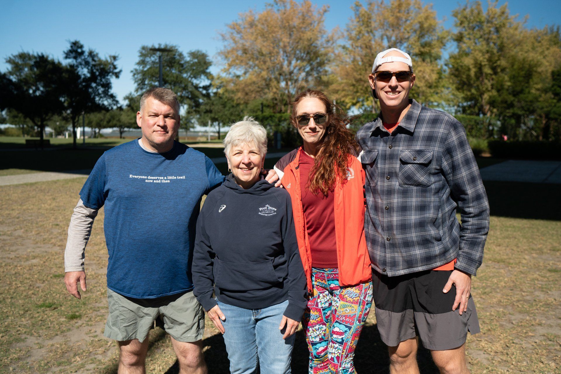 A group of people are posing for a picture in a park.