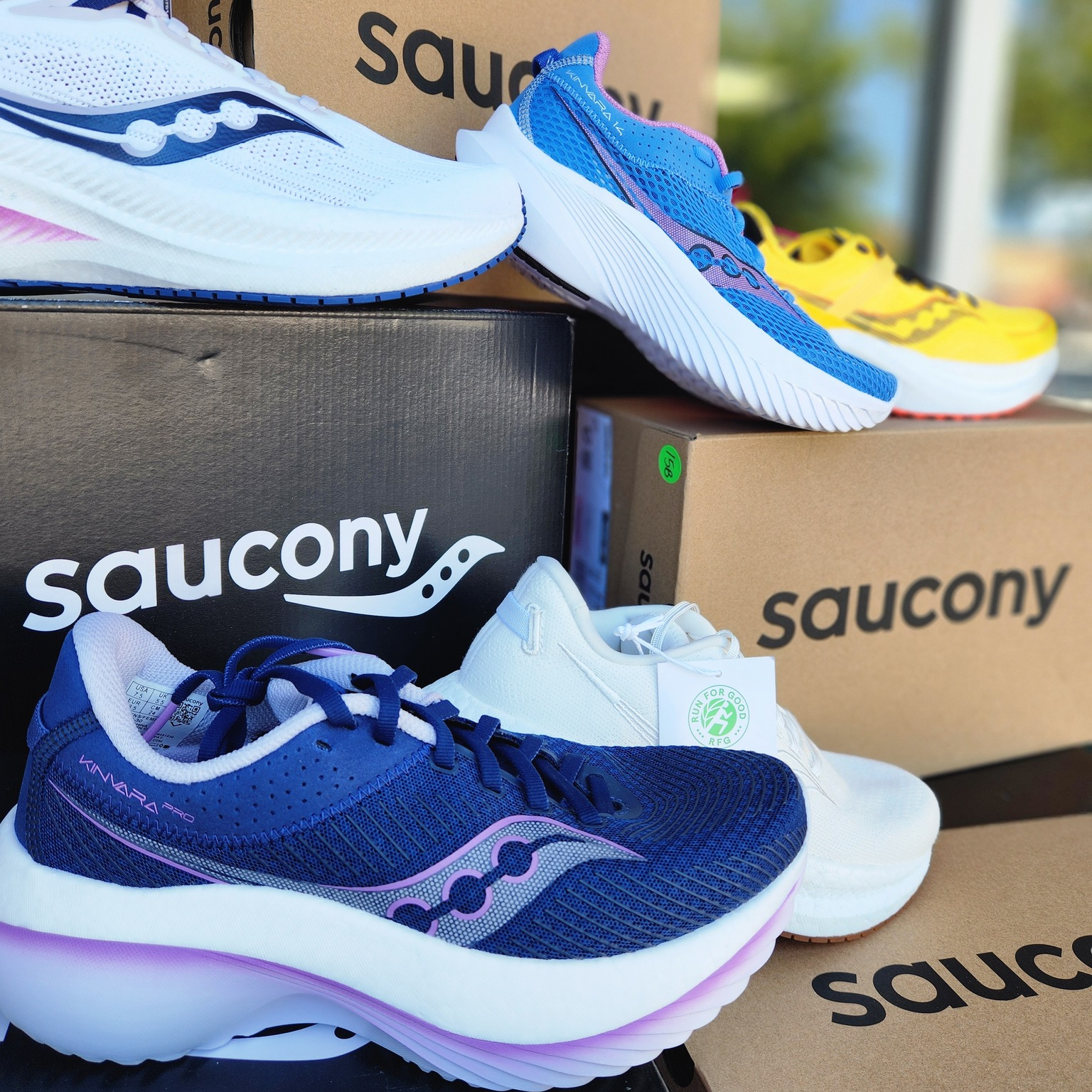 A bunch of saucony shoes are stacked on top of each other