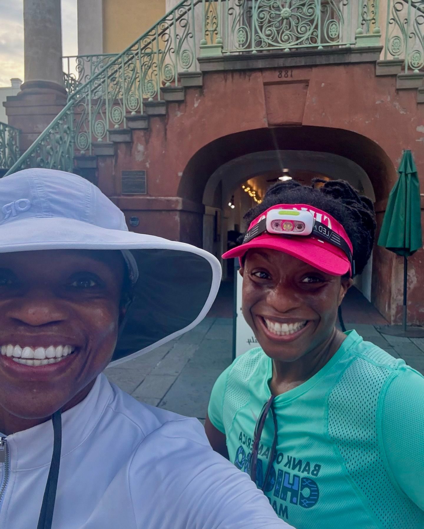 Two women are posing for a picture in front of a building