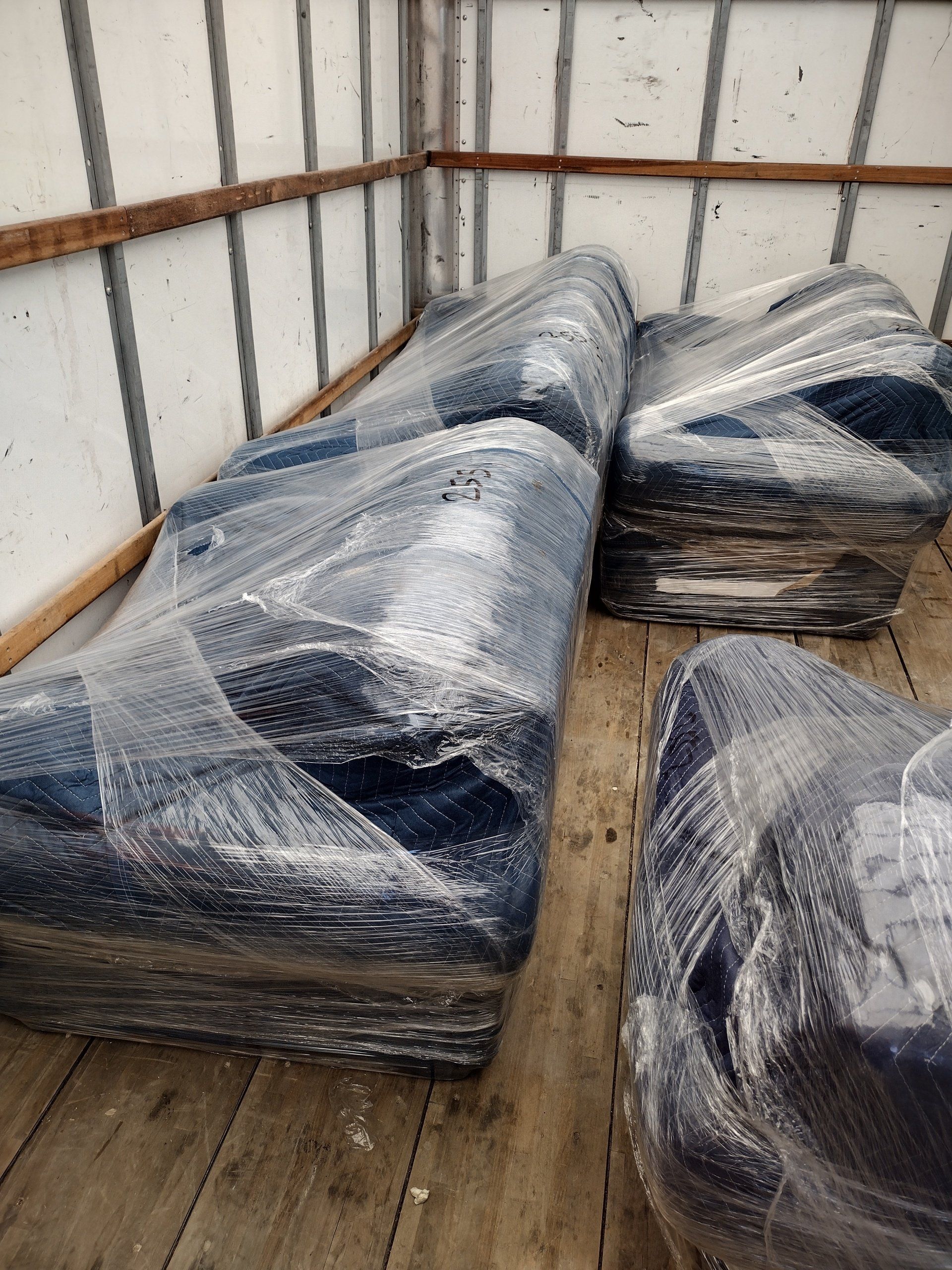 Wrapped furniture inside a truck bed, ready for transport.