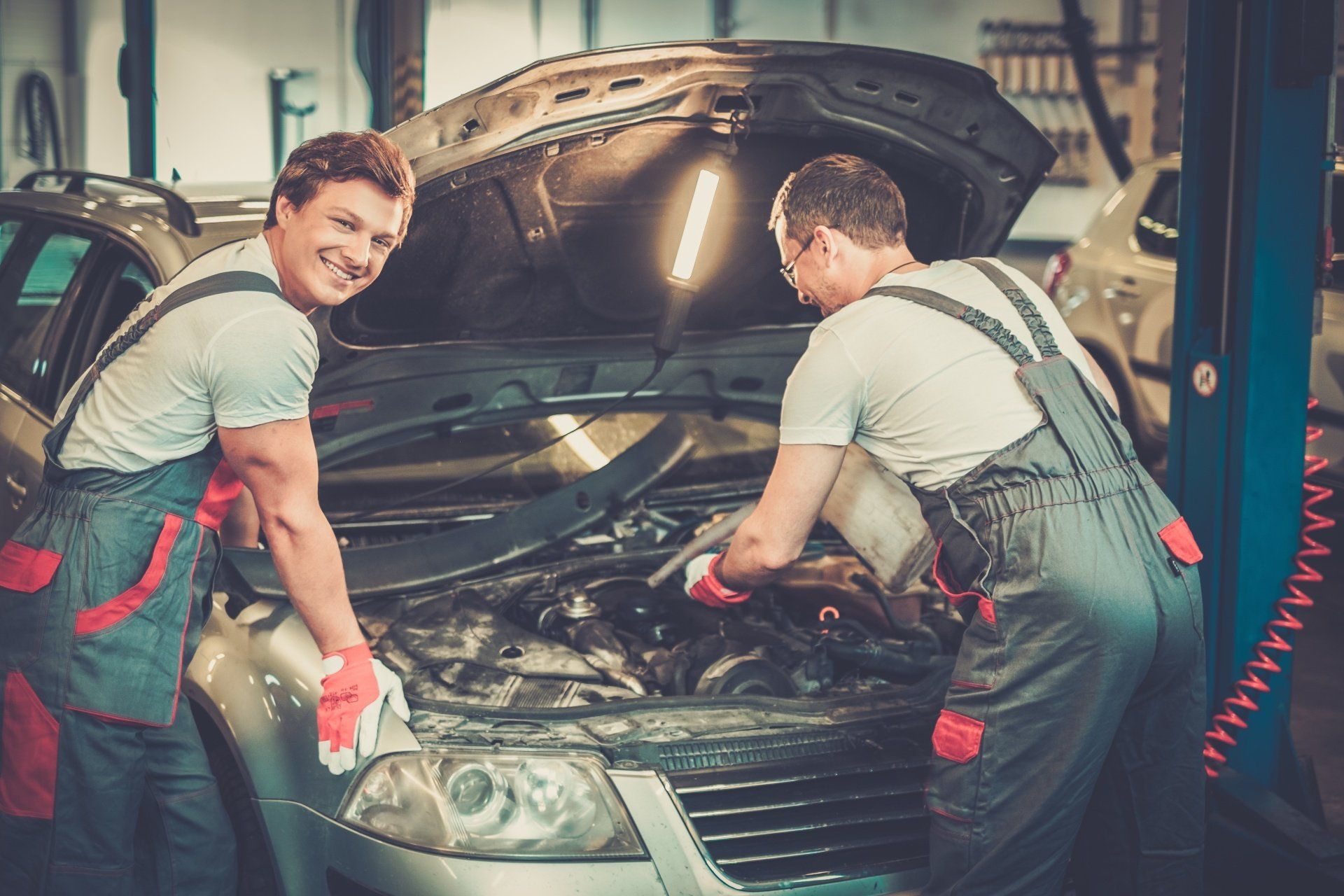 Two mechanics fixing car in a workshop