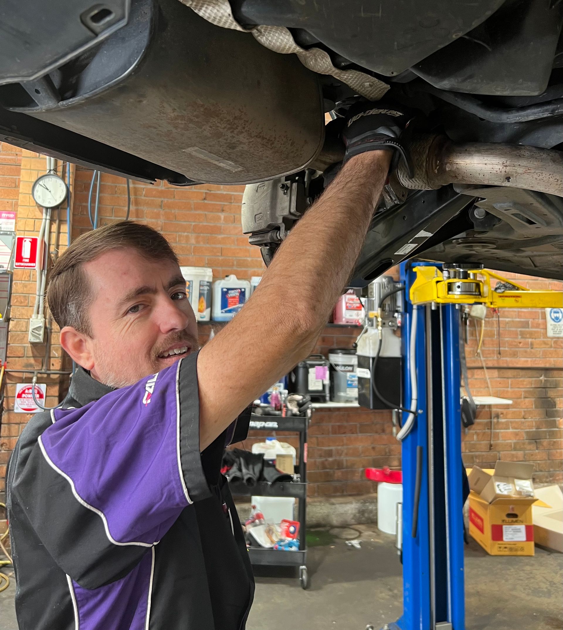 Mechanic Working On Car Tire — Servicing And Repairs in Lambton, NSW