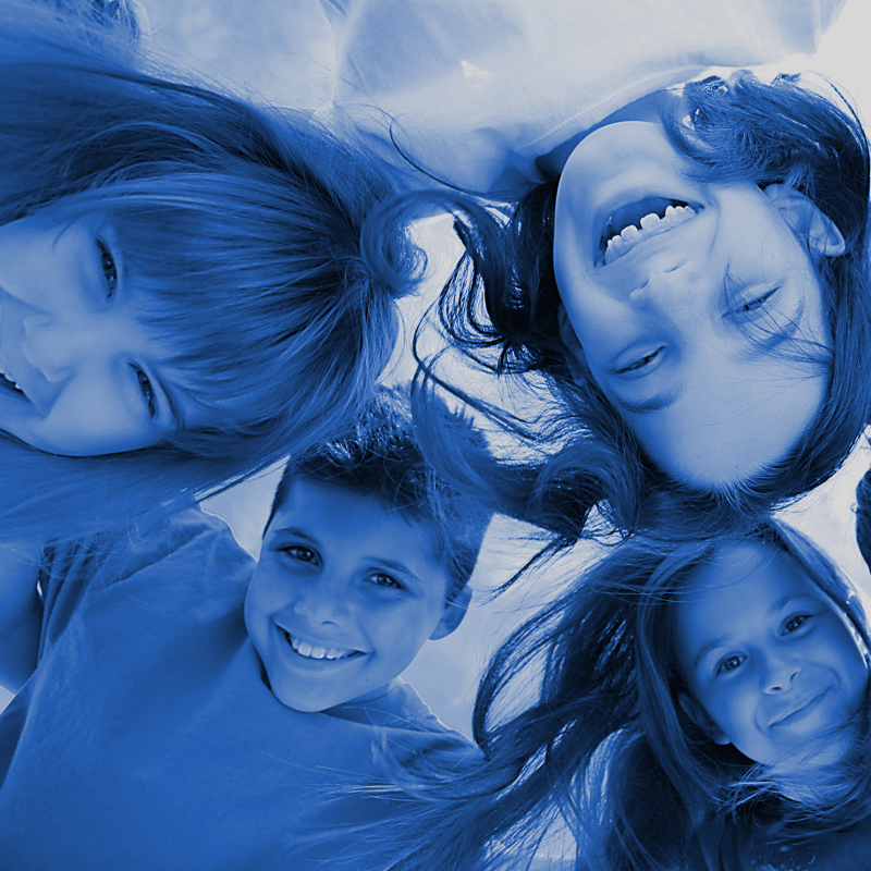 A group of children are laying upside down and smiling