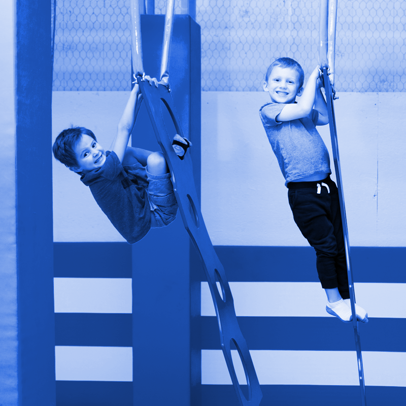 Two young boys are playing on a blue ladder