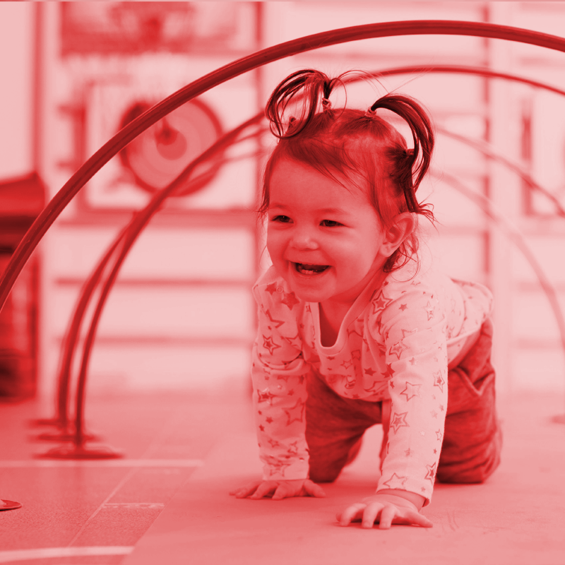 A little girl is doing a split on a blue mat