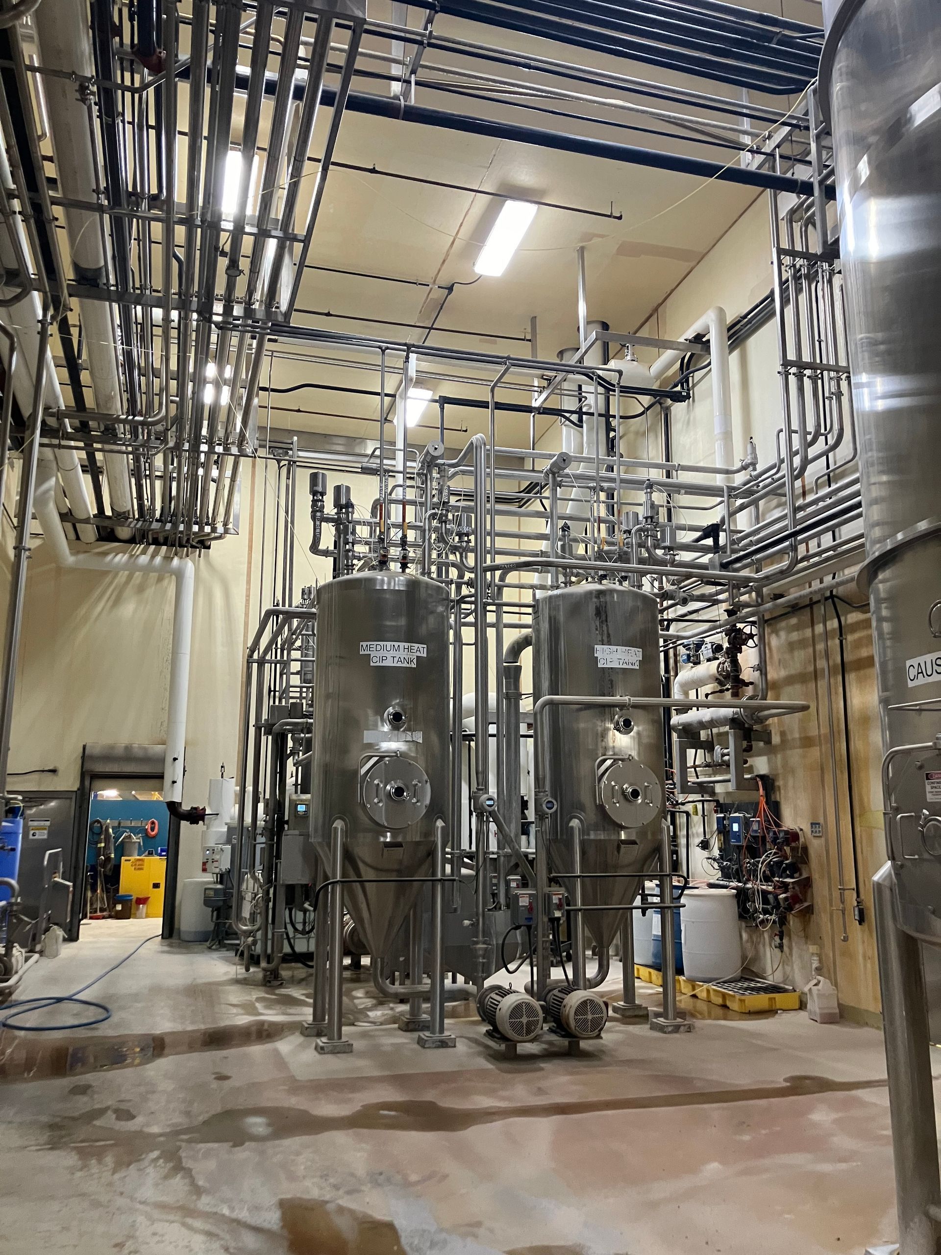 Stainless steel tanks and piping in an industrial processing facility.