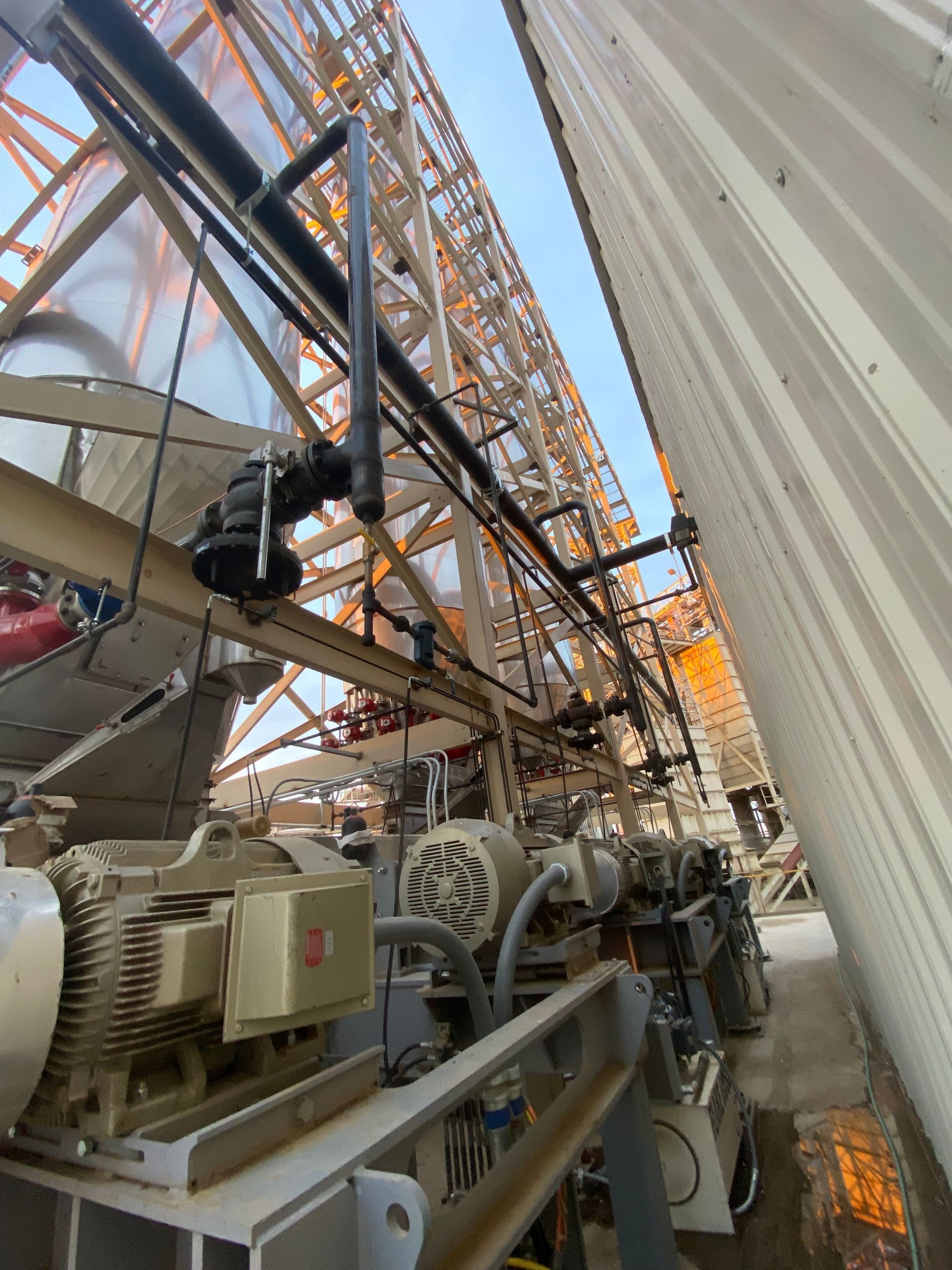 View up at drilling rig equipment with piping and motors.