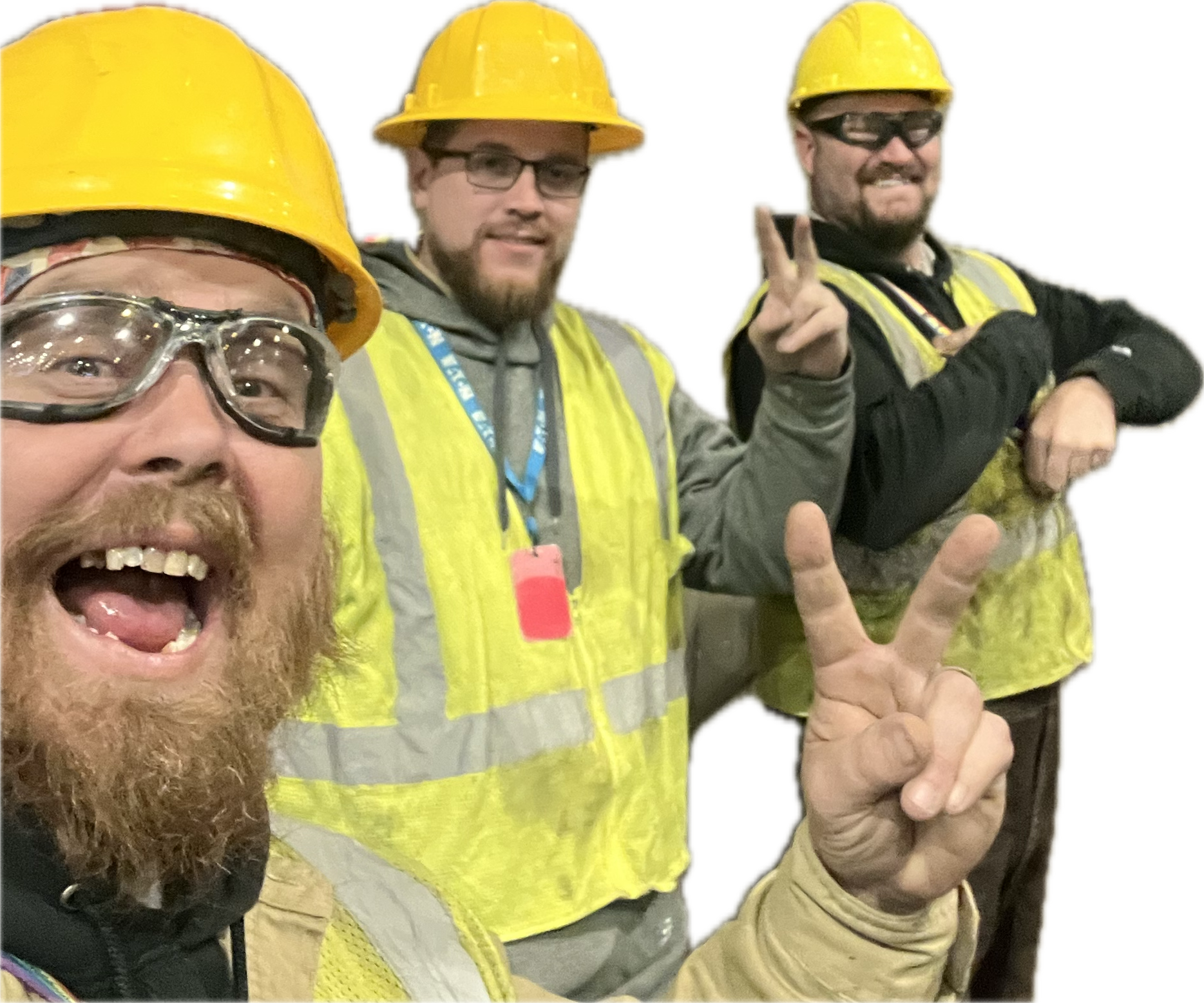 Three construction workers in yellow helmets and vests, making peace signs and smiling.