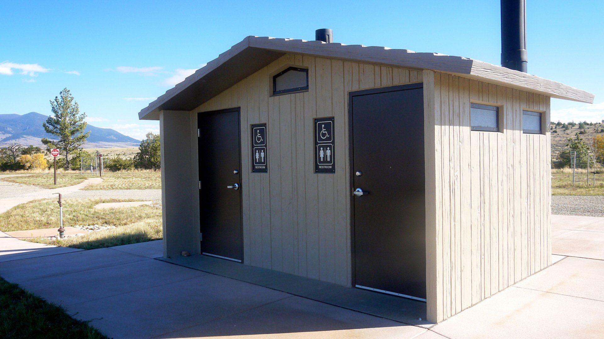 A small shed with two toilets on the side of it