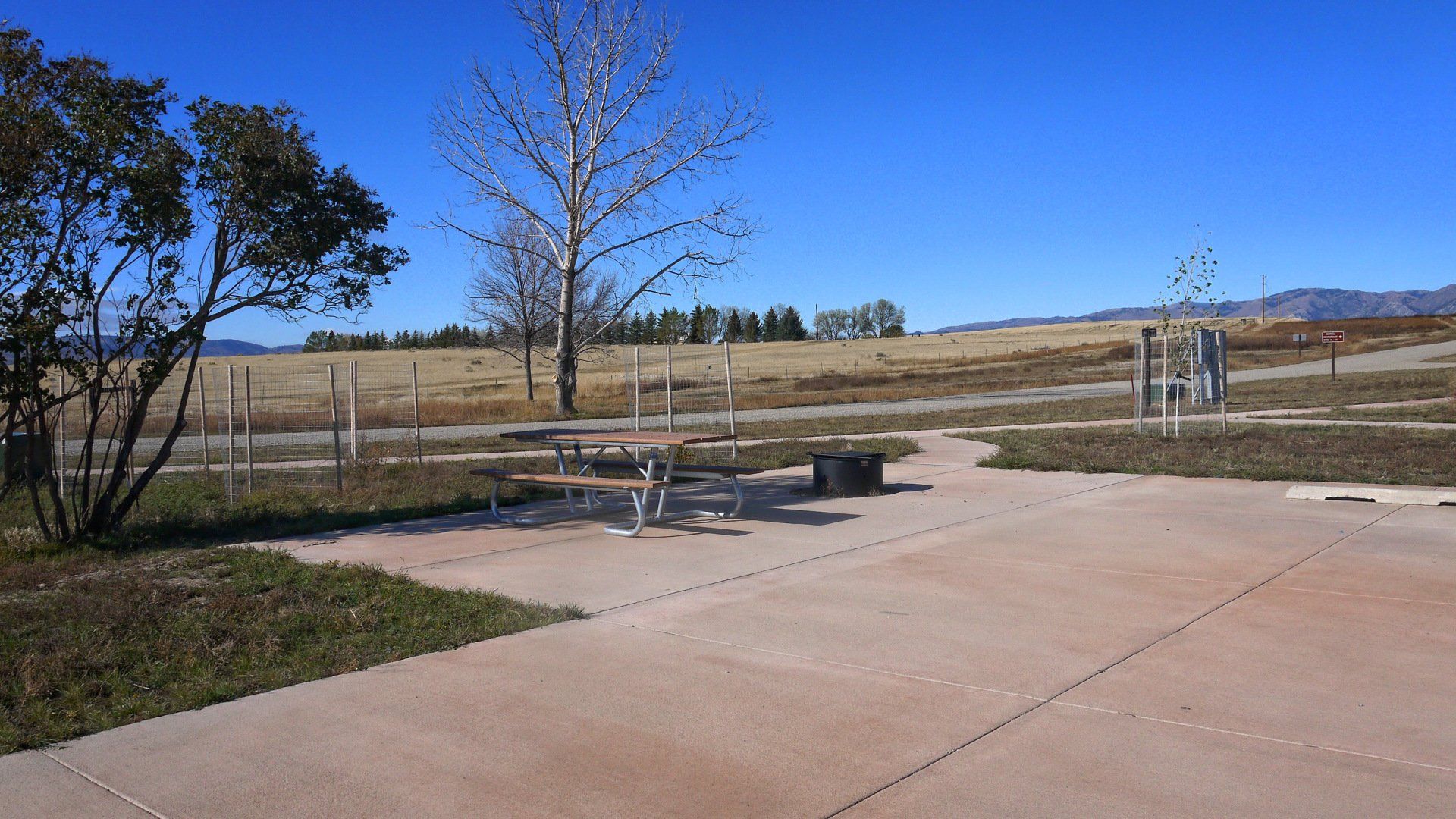 A picnic table is sitting in the middle of a parking lot.