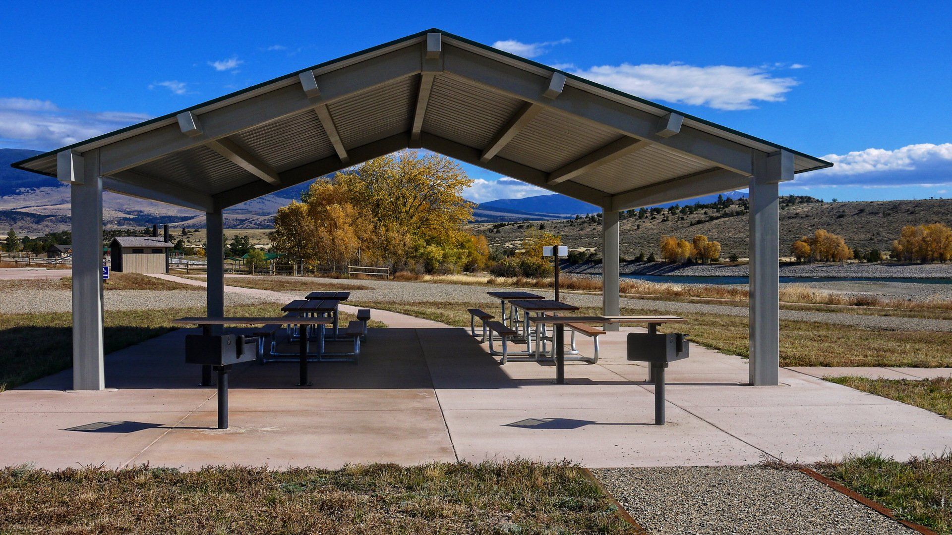 A picnic shelter with tables and grills in a park